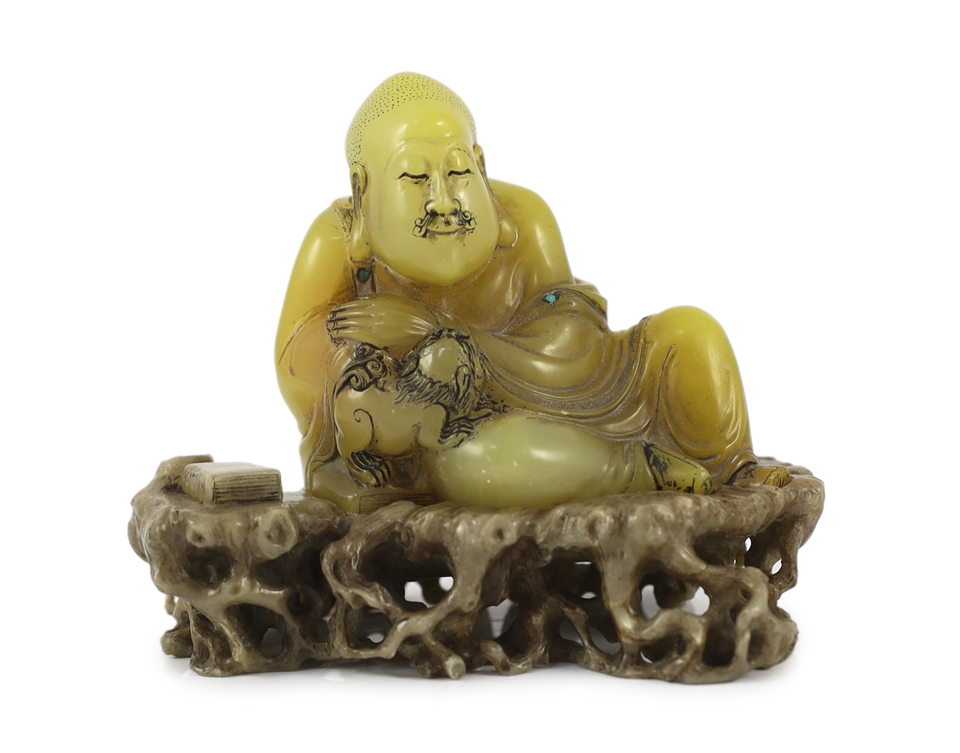 A Chinese soapstone seated group of a luohan and a lion-dog, on a soapstone stand, 18th century